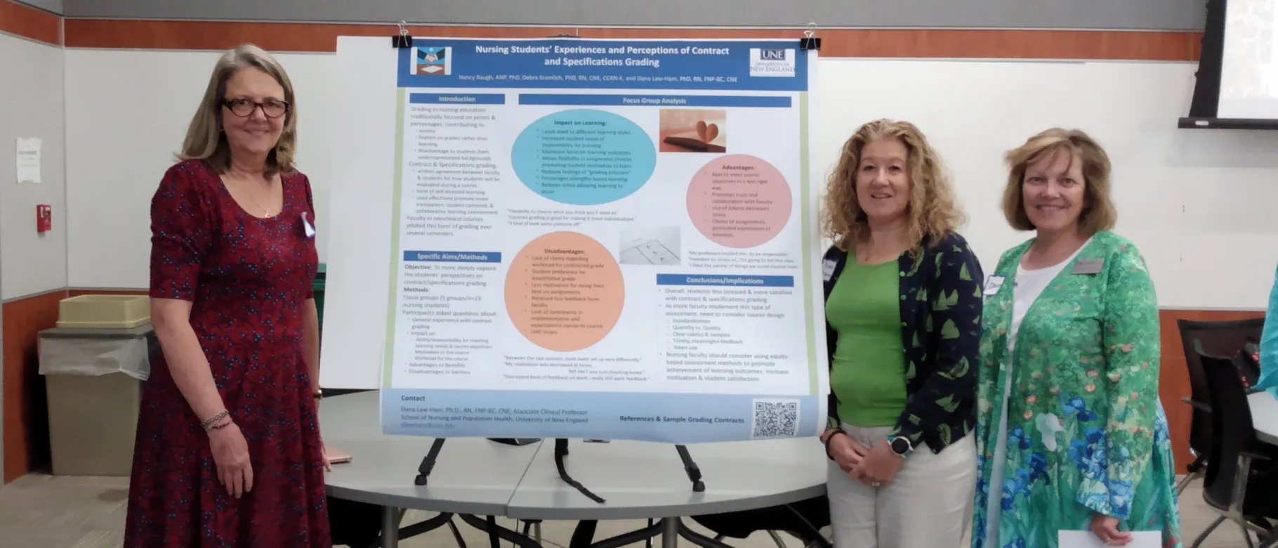 Three UNE faculty members stand next to a research poster