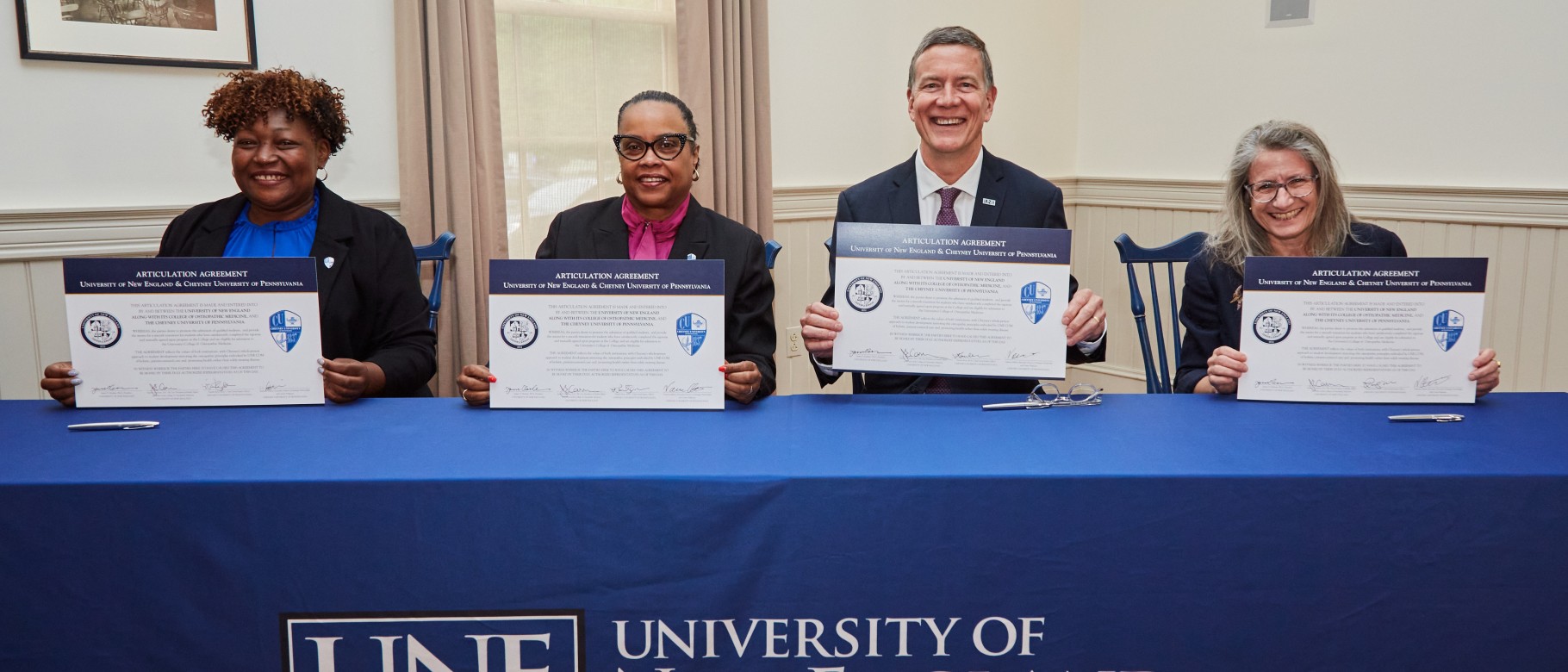 UNE and Cheyney University officials, including UNE President James Herbert and UNE COM Dean Jane Carreiro, hold signed copies of the articulation agreement