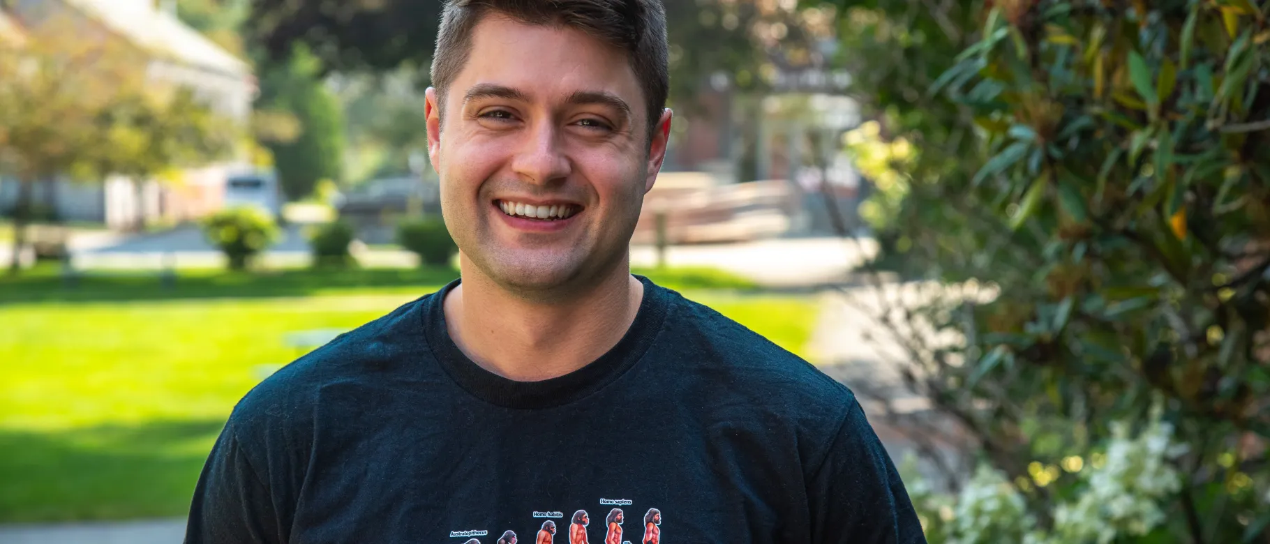 Robert Motley poses for a portrait on the quad outside UNE's Parker Pavilion. He wears a shirt that reads "Superhumans," which is the name of the clinic he volunteered at in Ukraine.