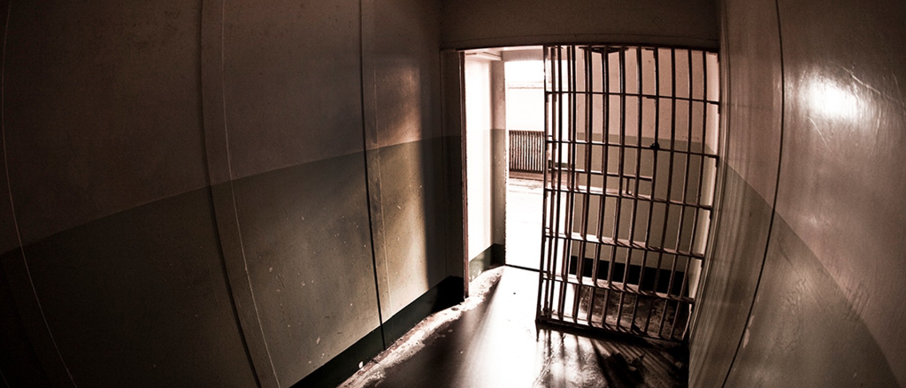 A dark photo shows the silhouette of a jail cell