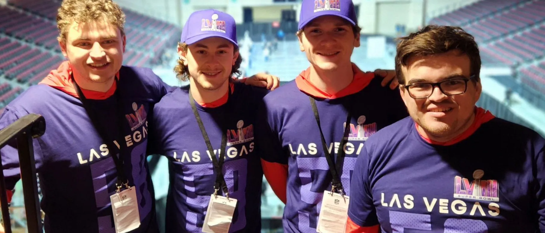 Four students pose wearing NFL-themed shirts
