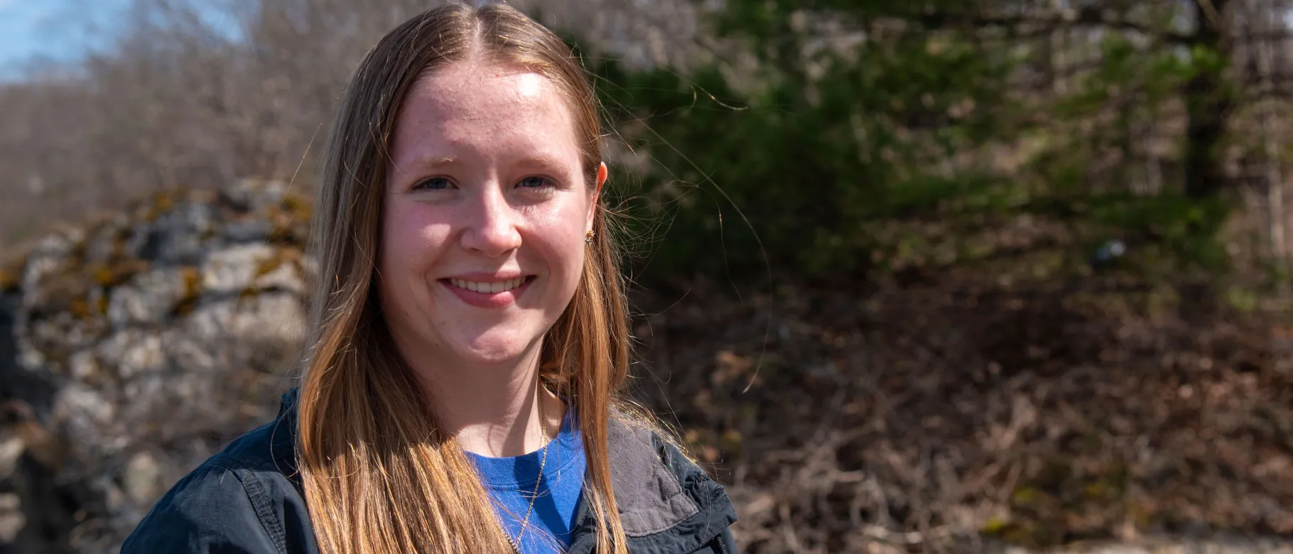 Portrait of a woman smiling in front of the forest