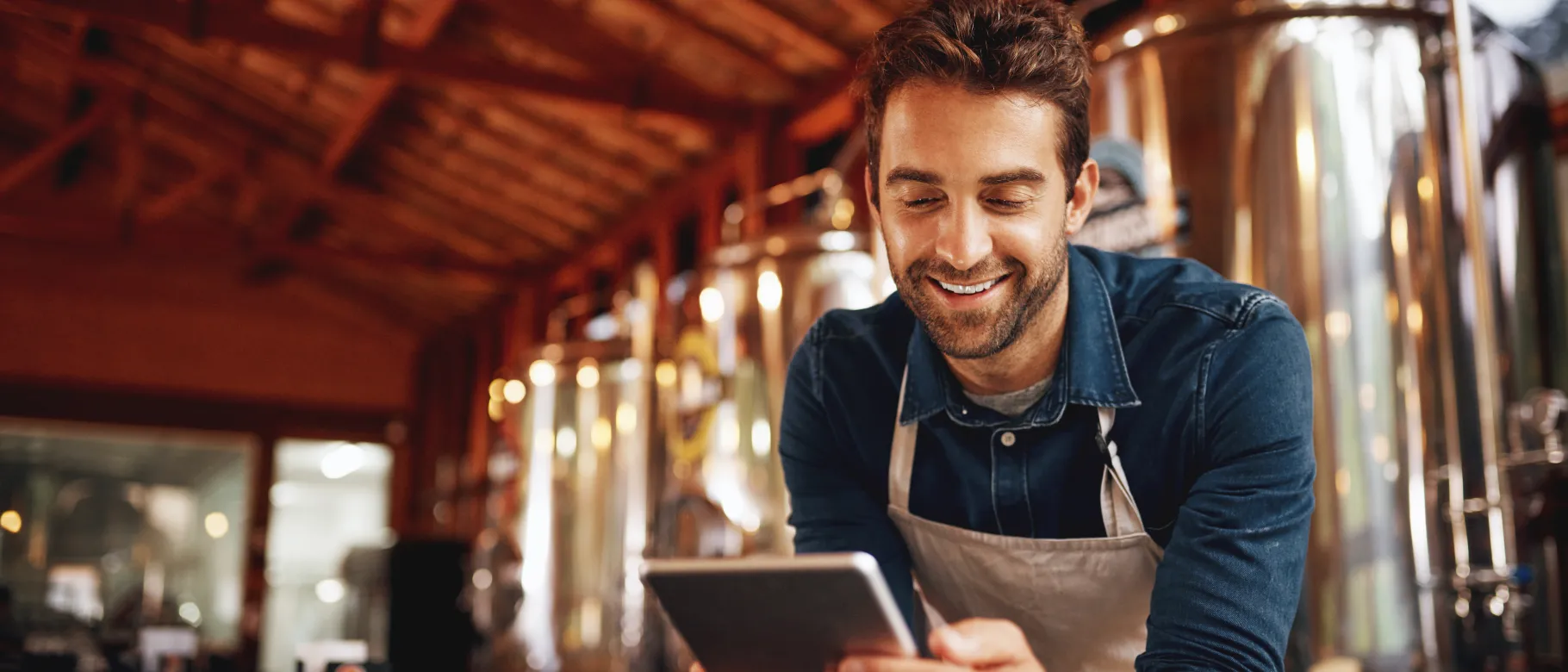 A mean uses a tablet inside a brewery
