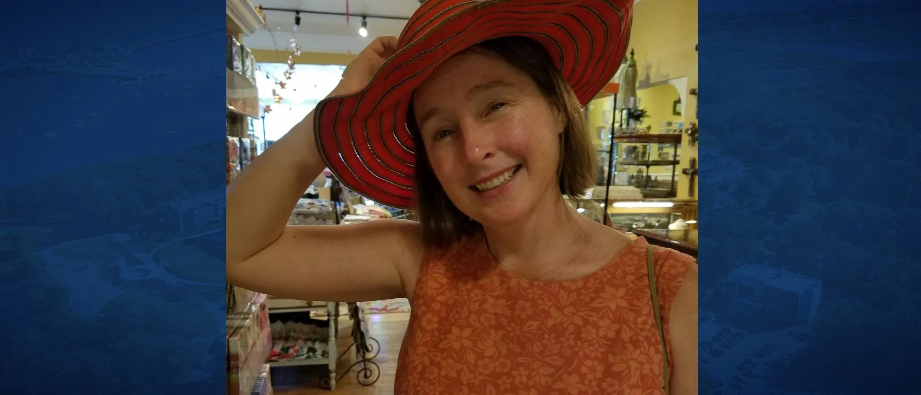 Susan McHugh poses wearing a red hat