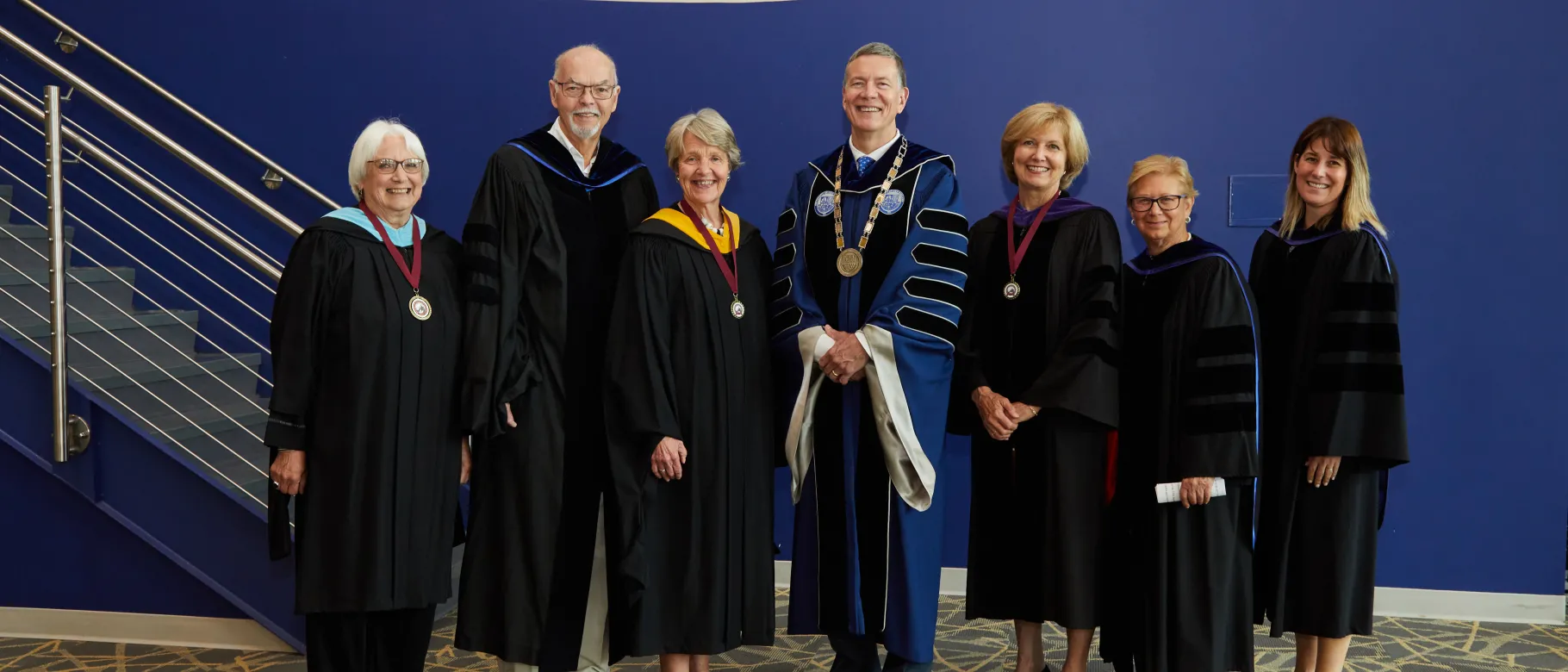 A group of people in regalia pose for a photo