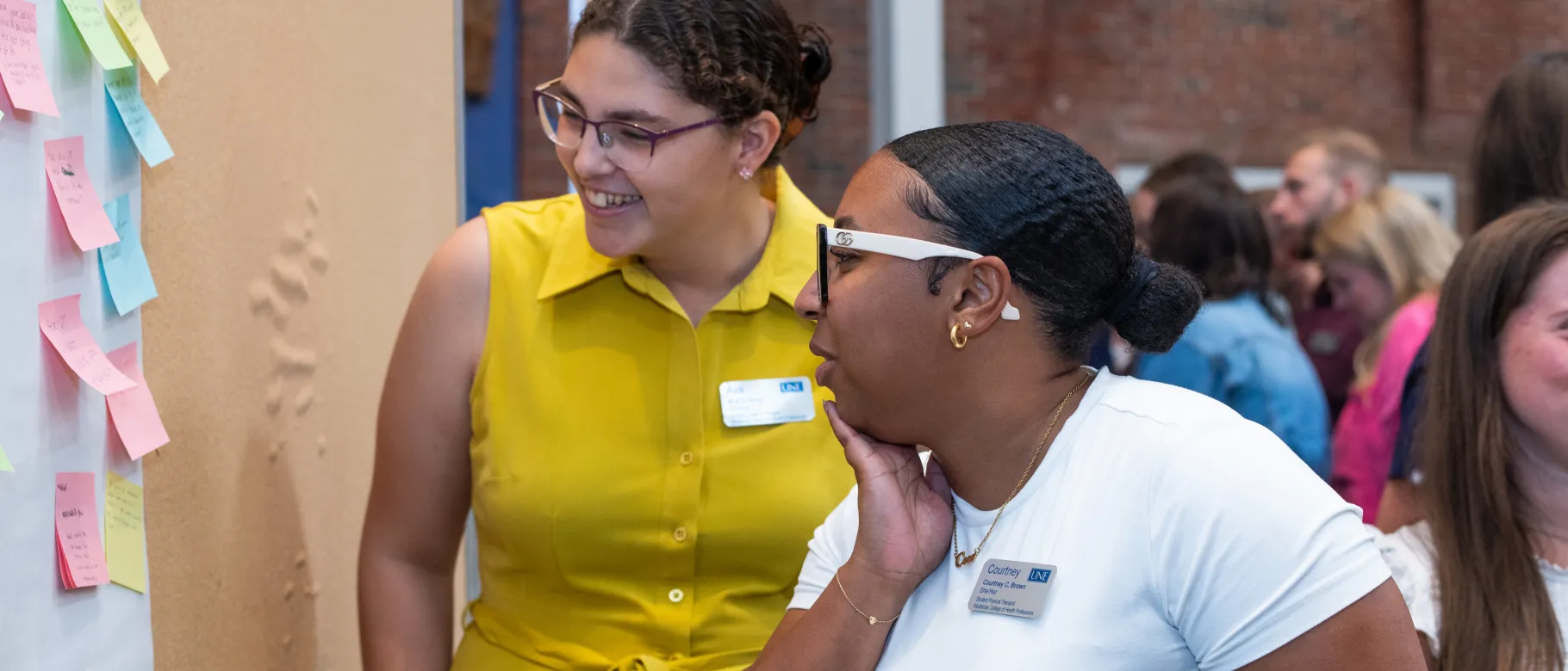 two students engage with questions on sticky notes