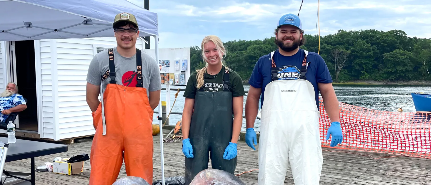 Three marine science students pose on the pier at Camp Ellis along the Saco River