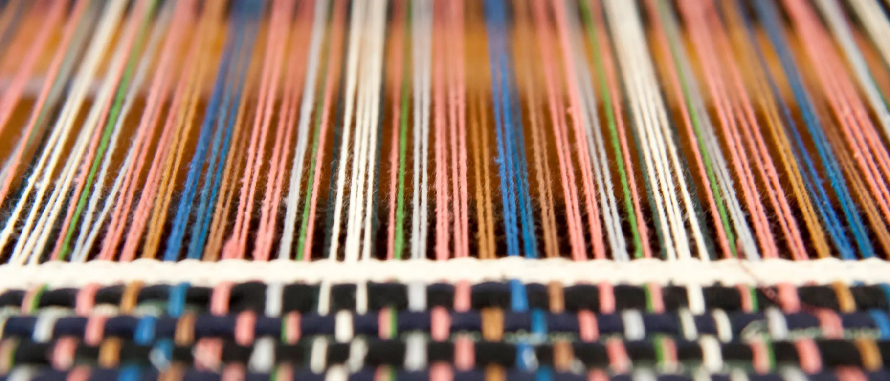 Spools of thread are shown along a loom