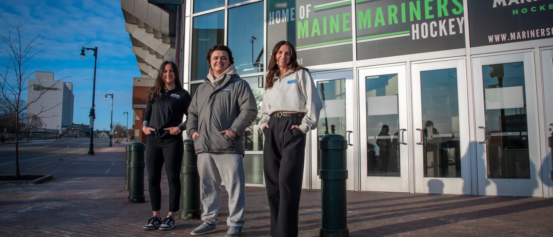 UNE students pose in front of the Cross Insurance Arena in Portland