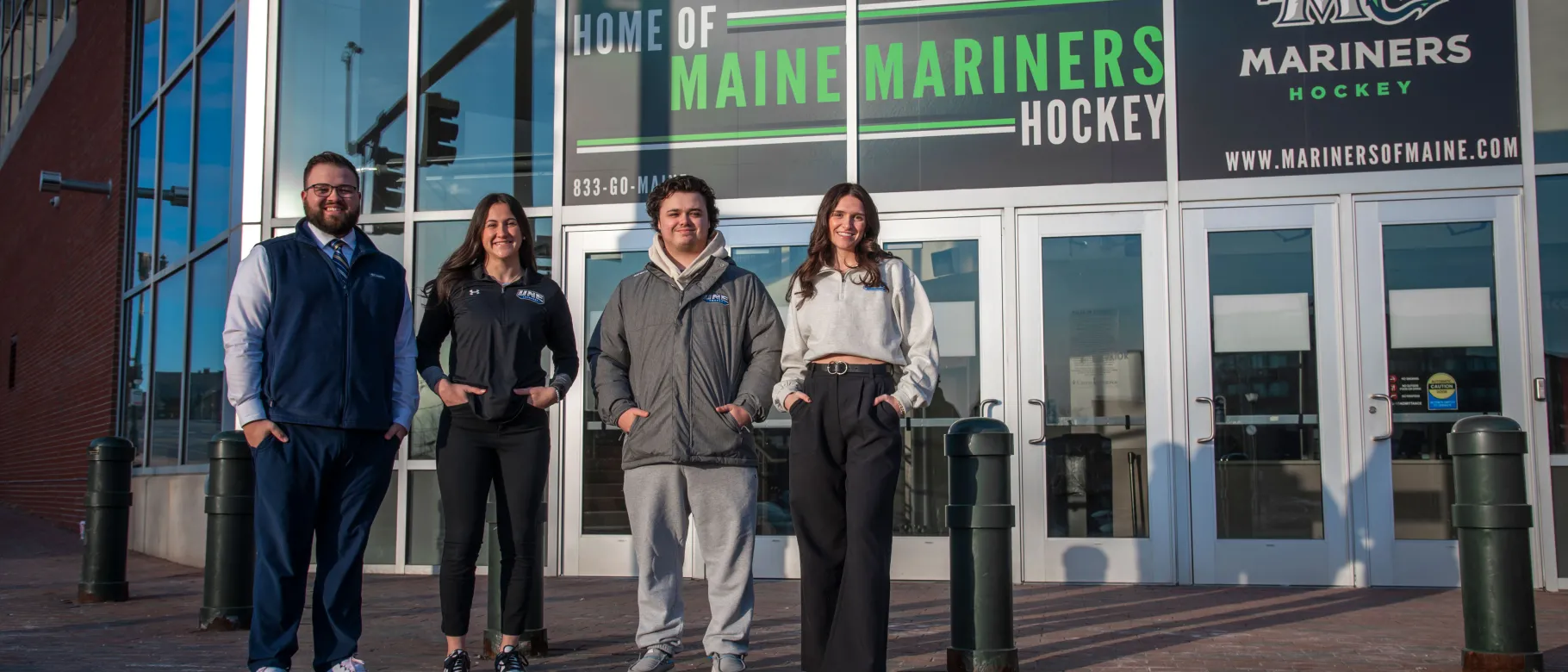 UNE students pose in front of the Cross Insurance Arena in Portland