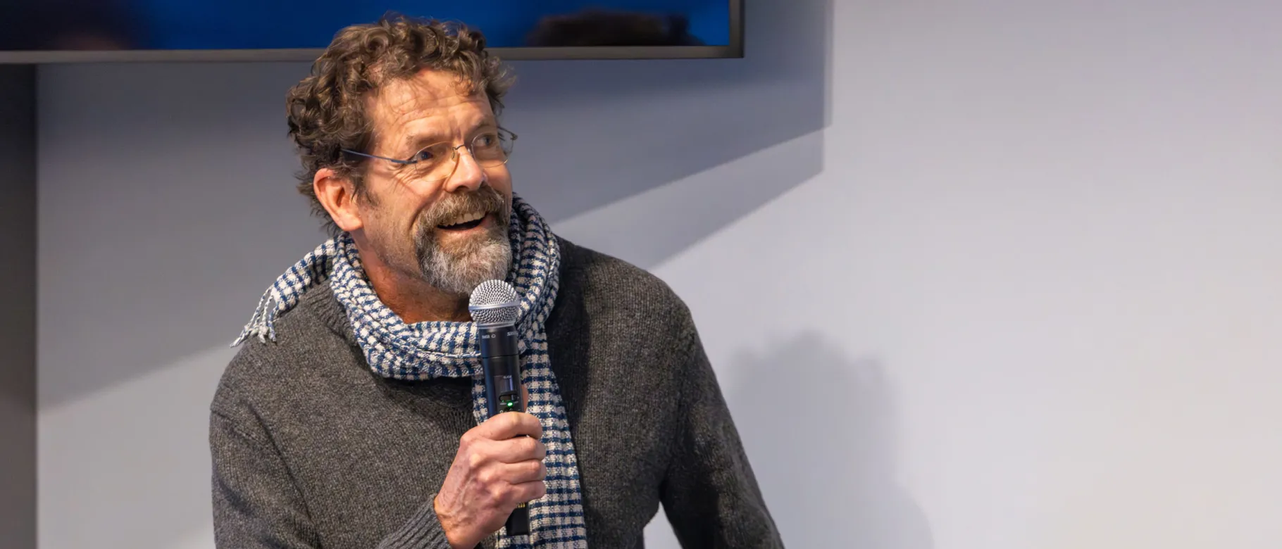 Stephen Burt speaks into a microphone onstage