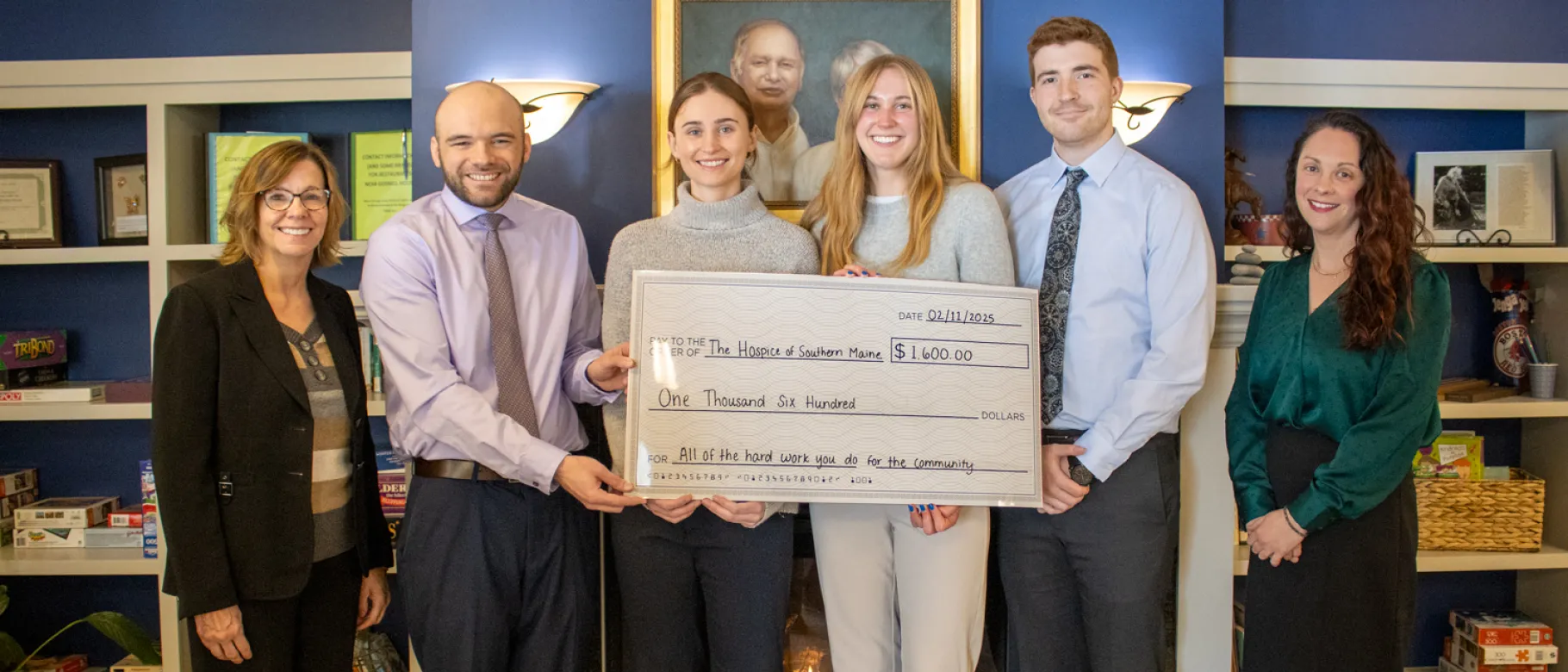 UNE medical students and local health leaders pose holding a large check in the amount of $1,600