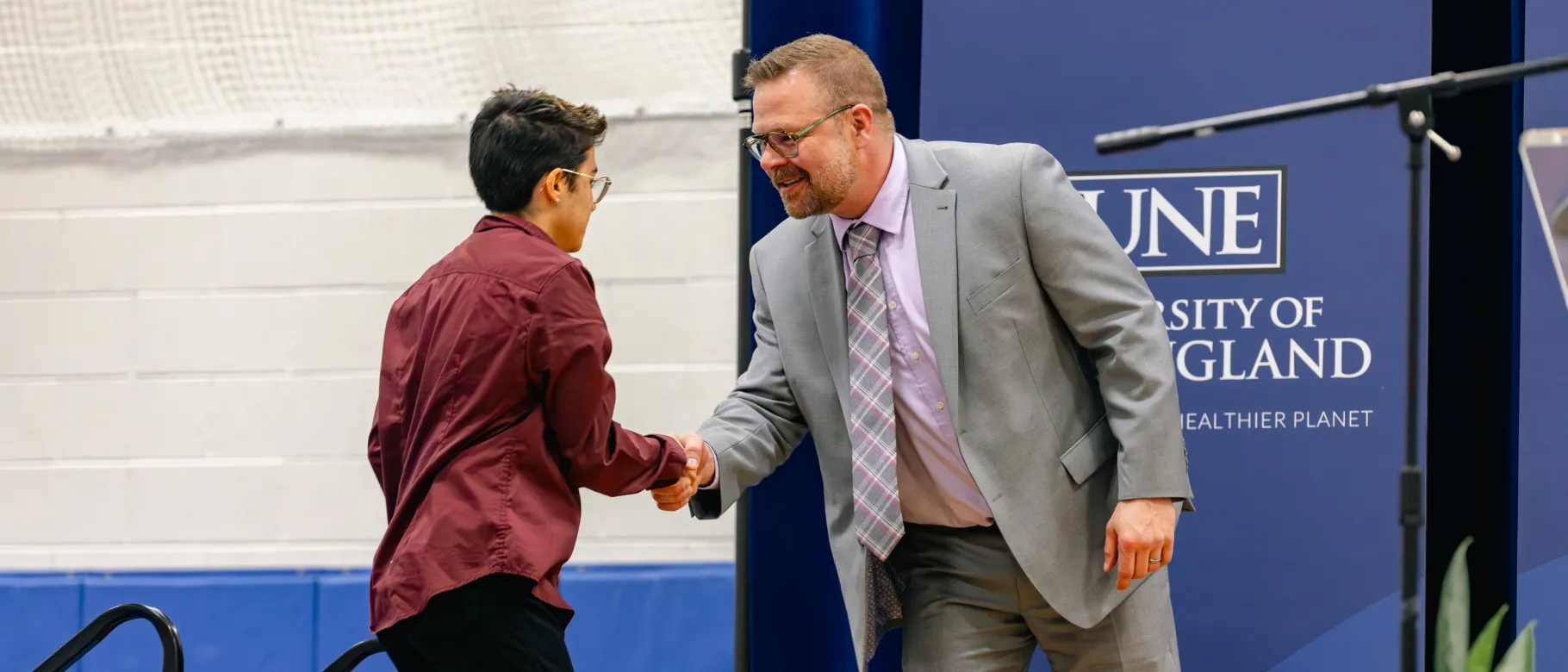 Wes Renfro shakes hand with a student at University Award Ceremony