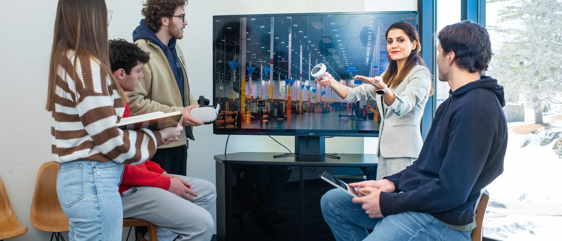 Faculty and students interact with virtual reality and discuss supply chain