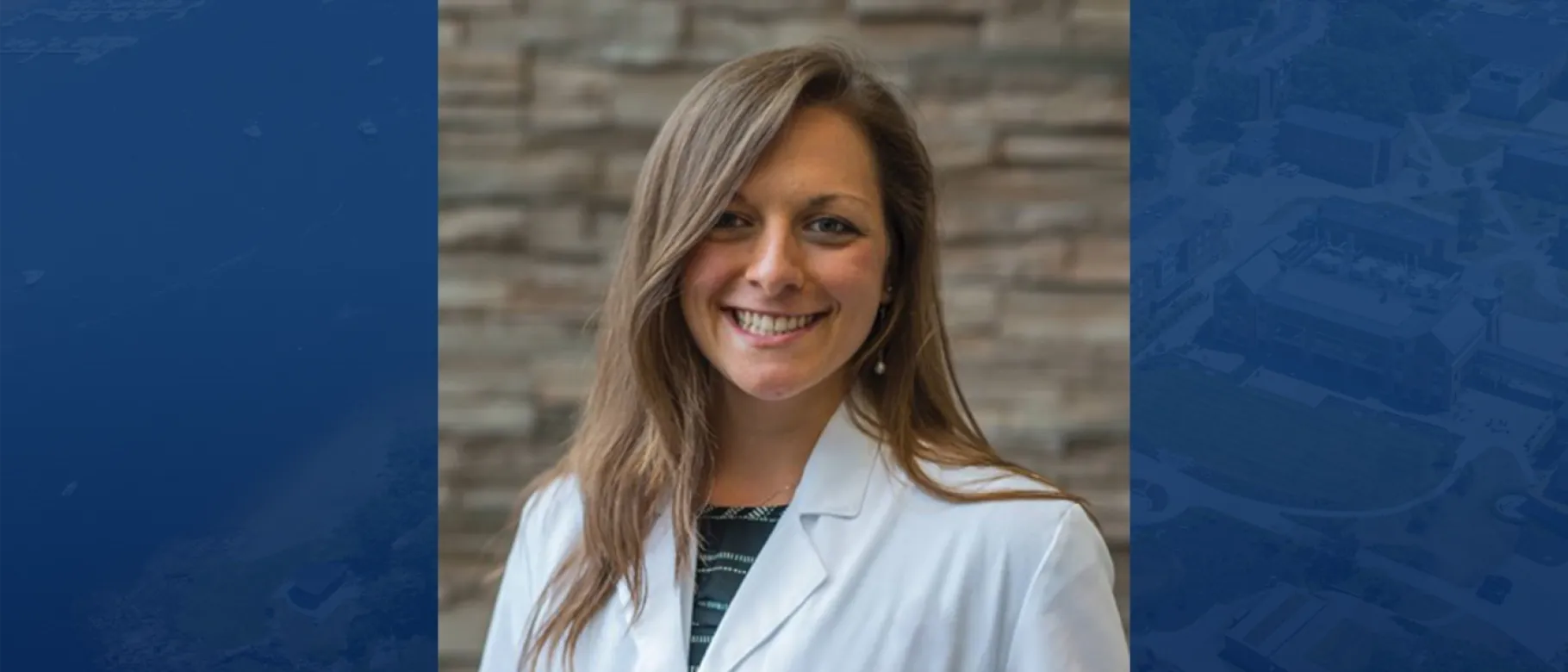 Headshot of Stephanie Podolski against blue backdrop