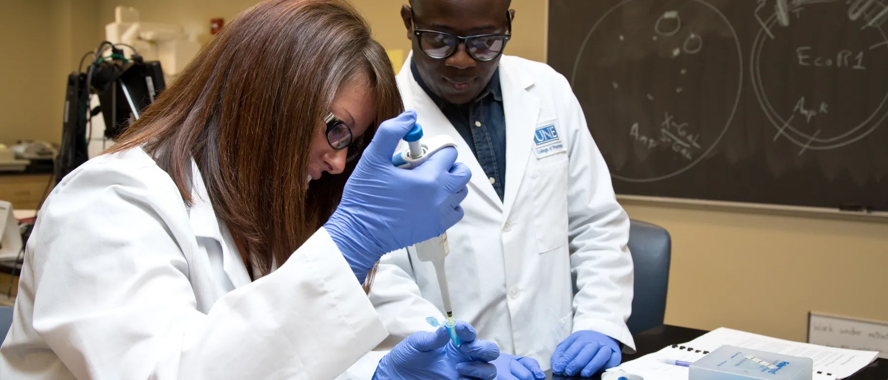 Photo of two UNE students performing scientific research