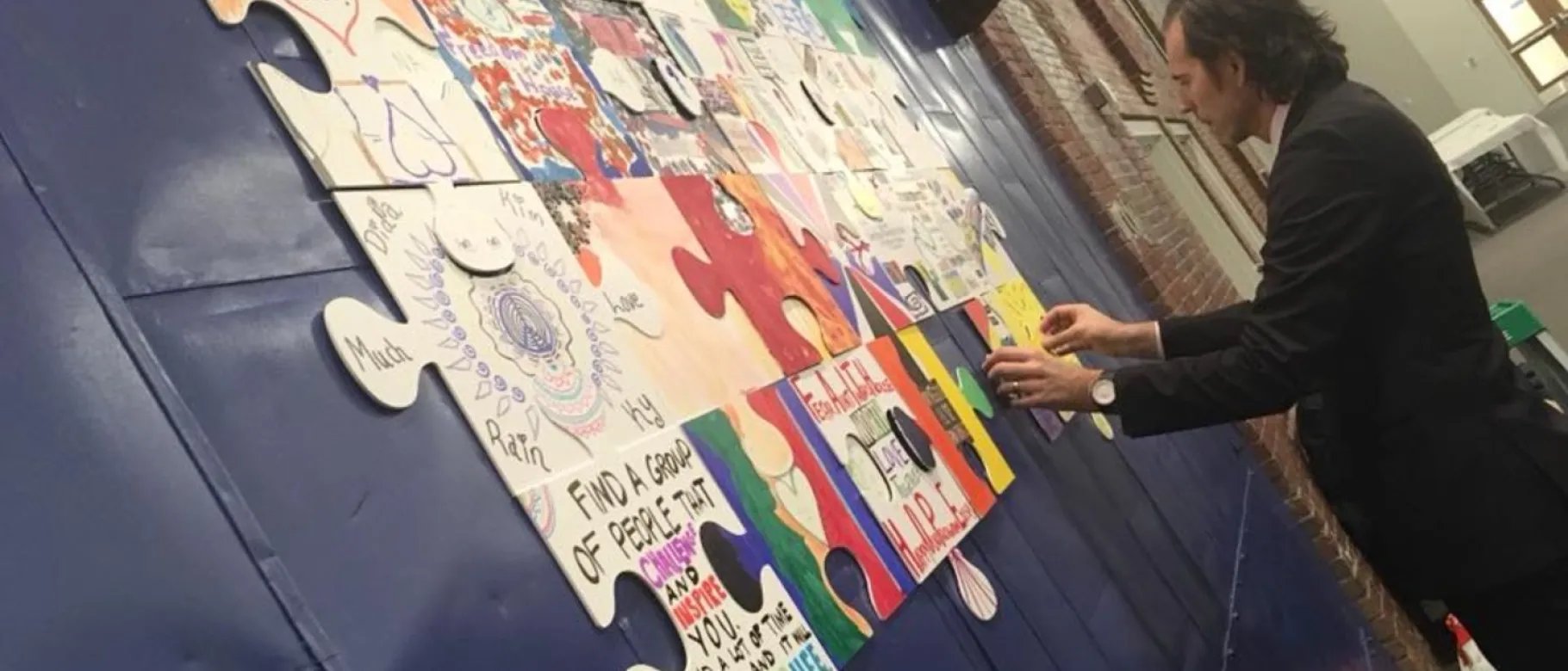 UNE social work student Glenn Simpson unveiled his recovery puzzle at the Southern Maine Harm Reduction Conference