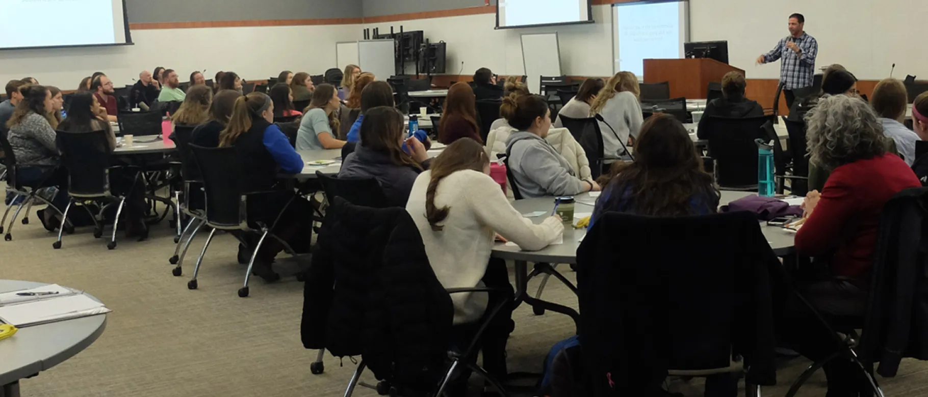 Derek Volk addresses a crowd of UNE students and community members