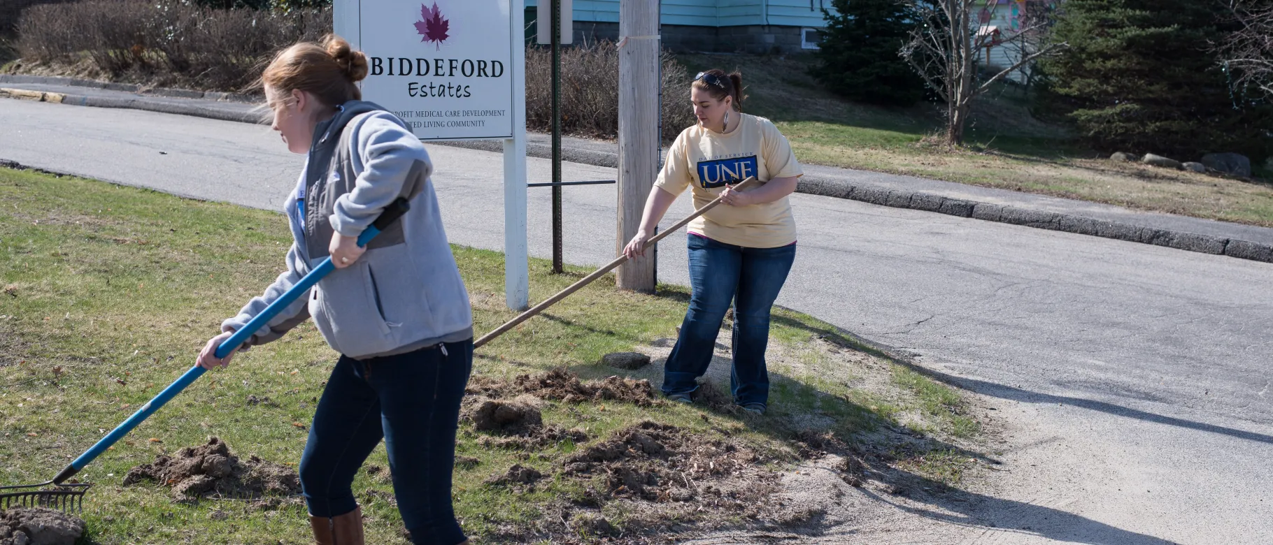 Sarah Nelson (left) and Samantha Funk perform yard work at Biddeford Estates.
