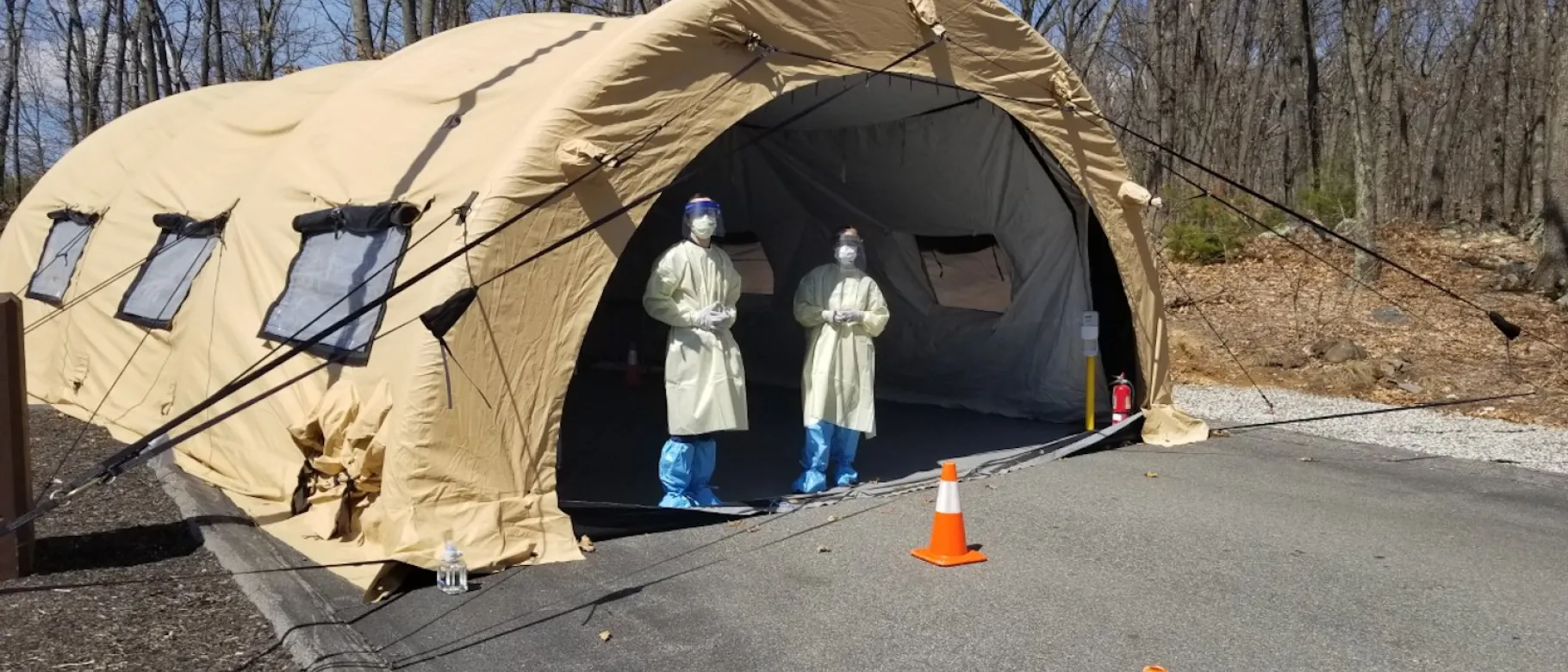Third-year UNE COM students Matt DiOrio (left) and Katelyn Chadwick (right) stand outside a drive-thru COVID-19 testing facility