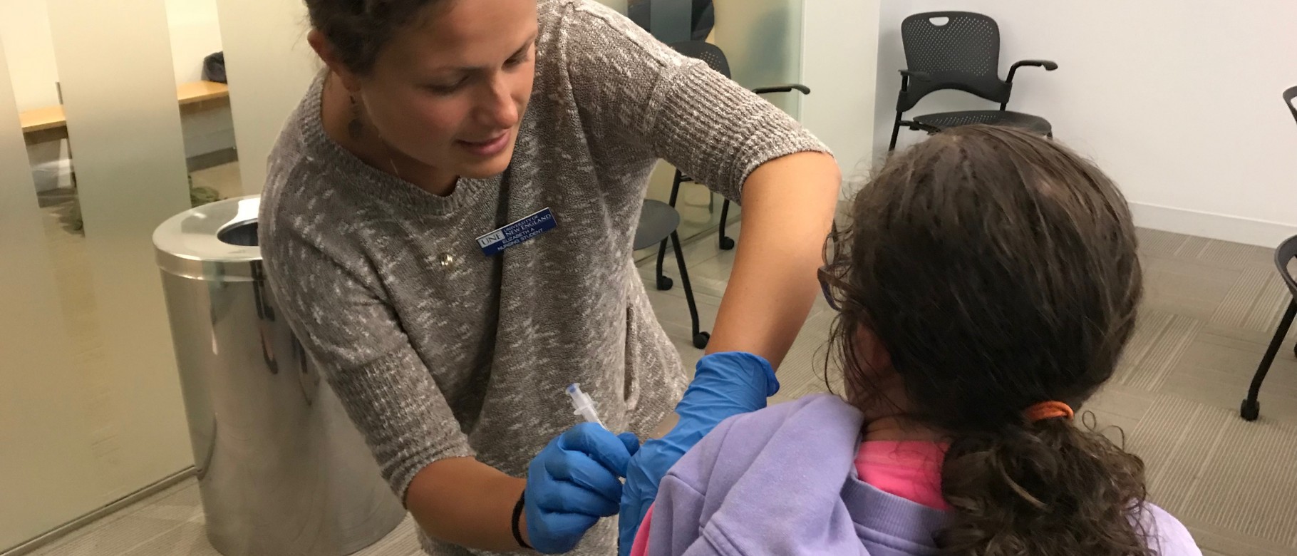 Nursing student Elizabeth Alvin administers a flu shot to a health fair visitor