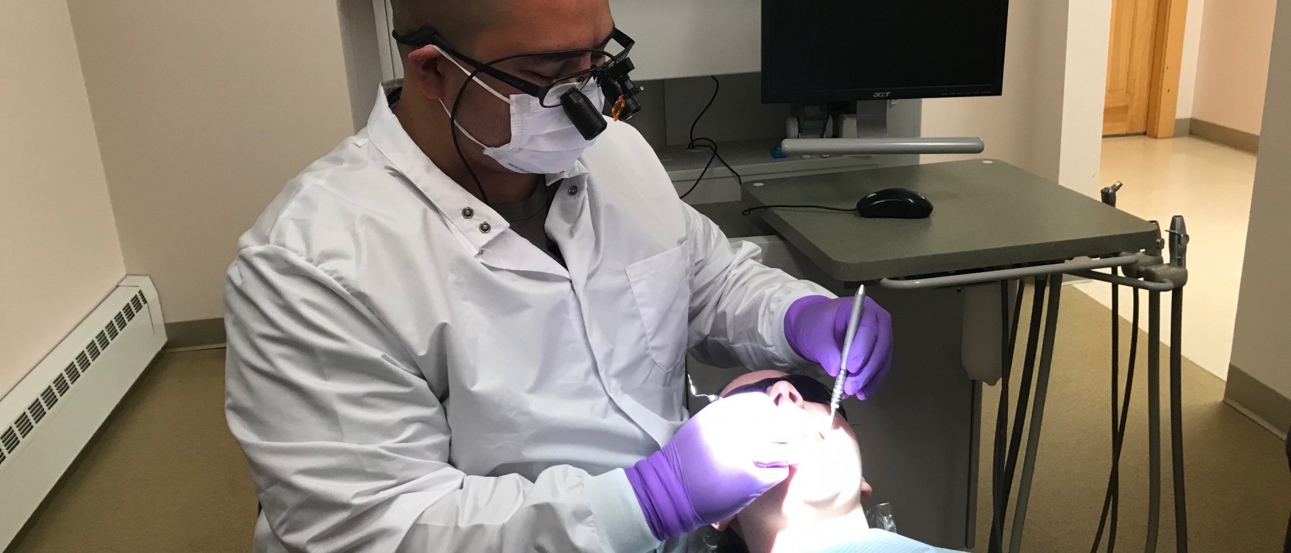 Recent UNE graduate C.J. Castonguay performs a procedure on a patient at the Katahdin Valley Health Center