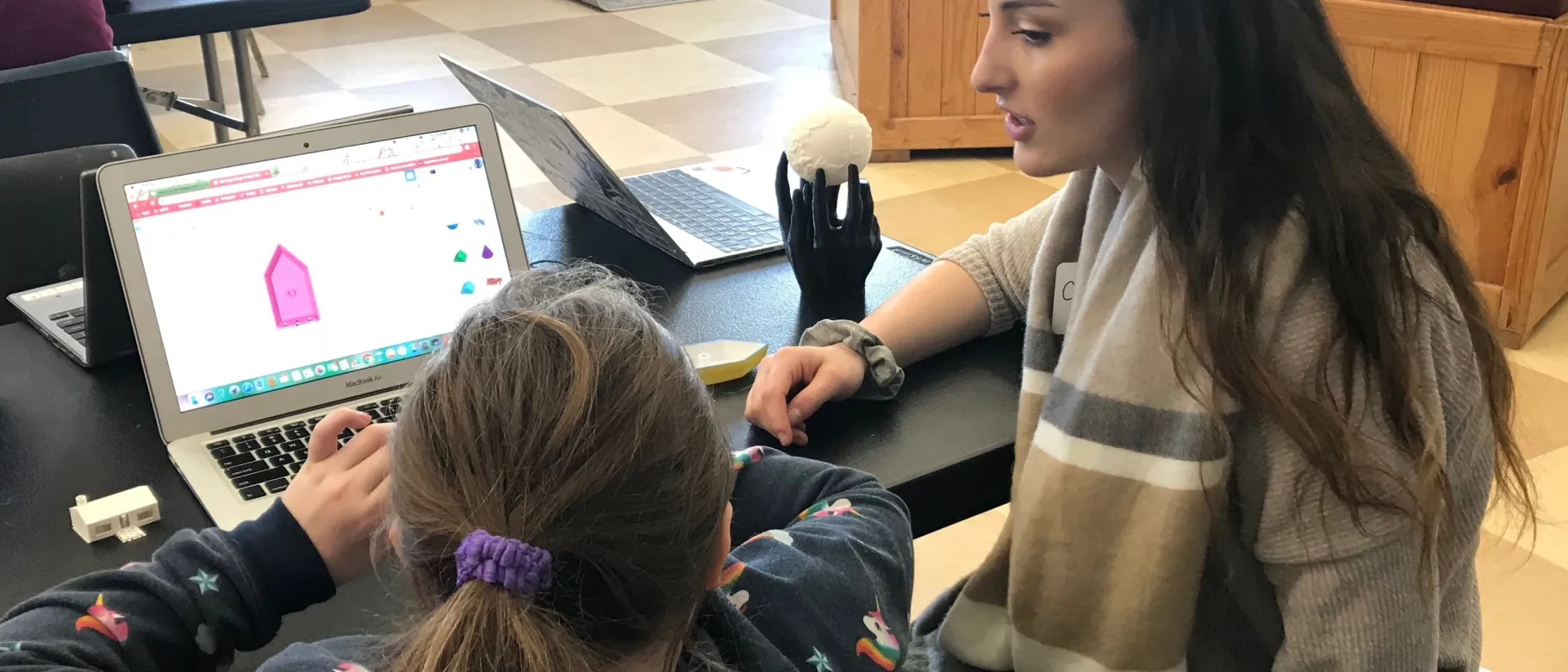 Elementary Education major Corryn Lachance helps a member of the Boys and Girls Club design her sailboat