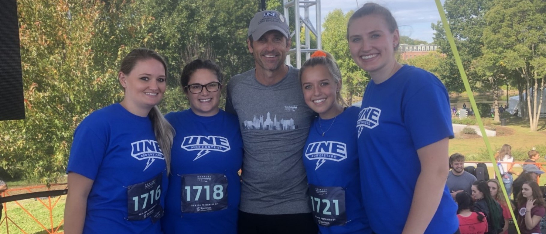 UNE students join Patrick Dempsey on stage for recognition and photos after the Dempsey Challenge