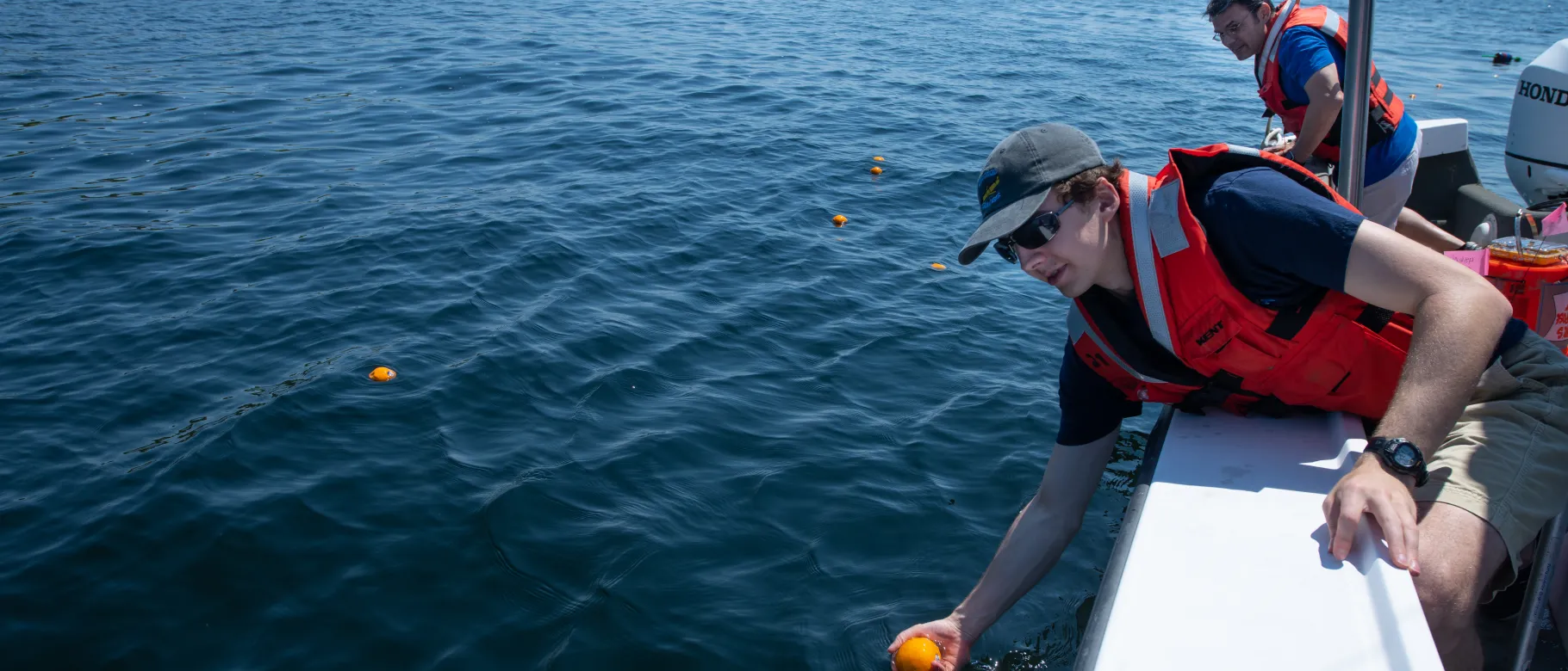 Andy Robinson (M.S. Marine Sciences, ’21) places oranges in the water in Biddeford Pool to track surface current movements.