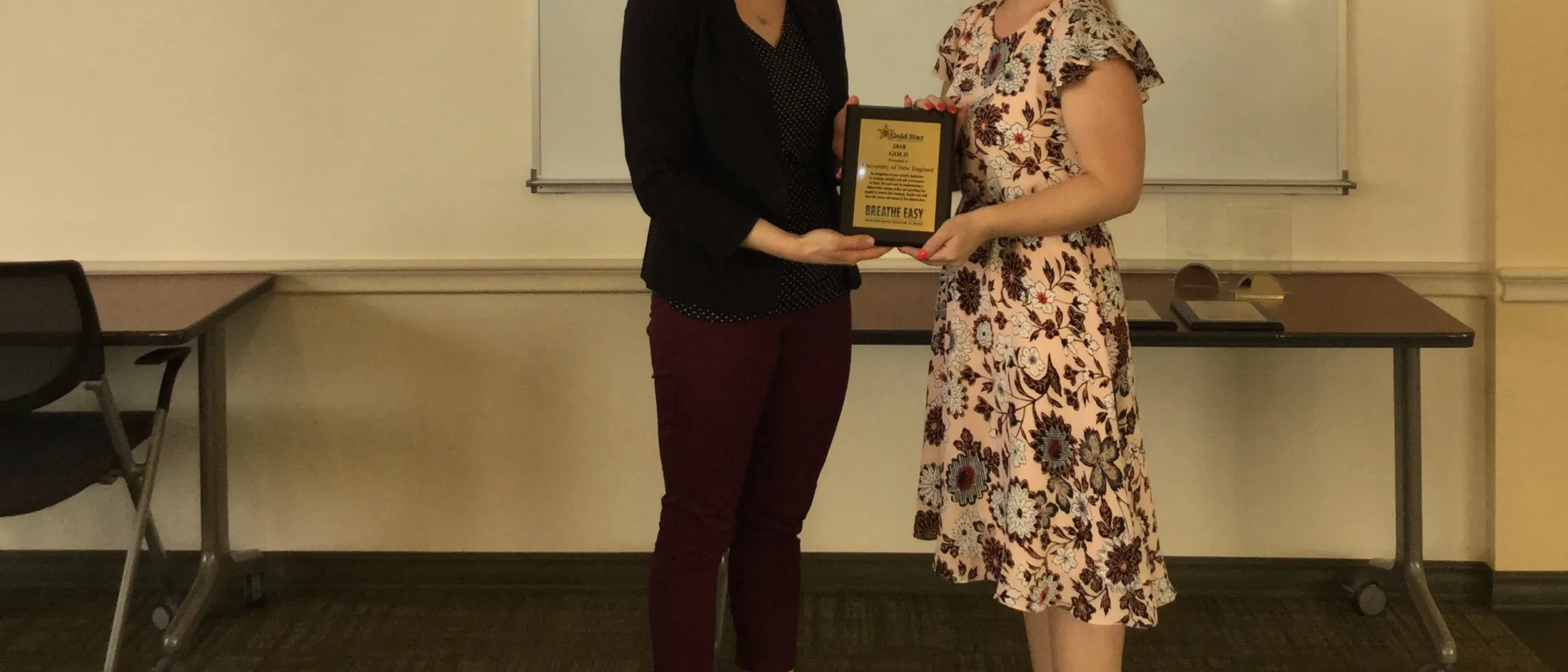 Cat Martins, UNE benefits and disability specialist, accepts the award