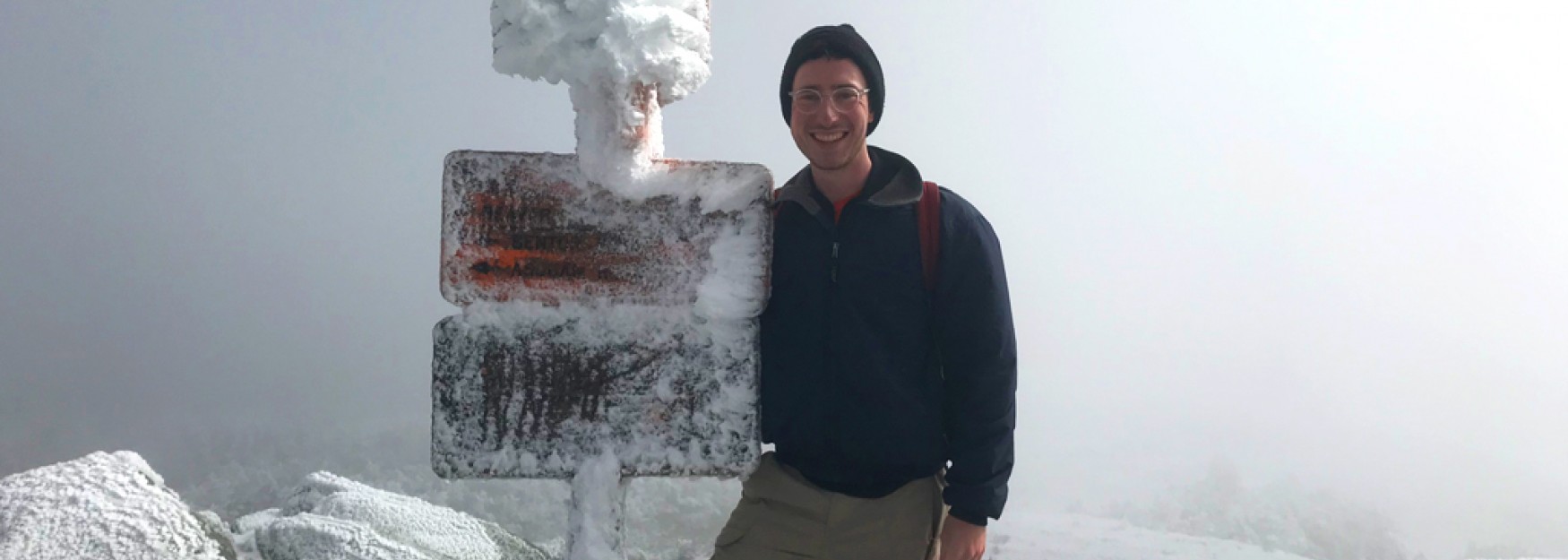 Mitchell Becker stands atop a snowy mountain in deep fog