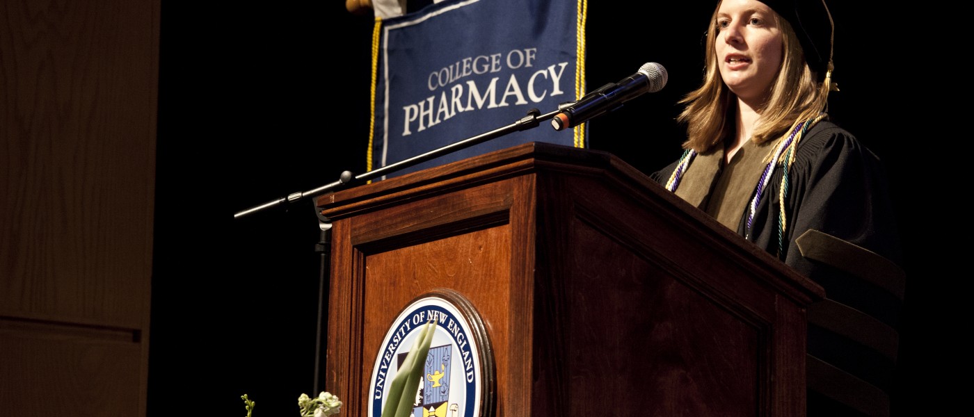 U N E College of Pharmacy graduate at podium