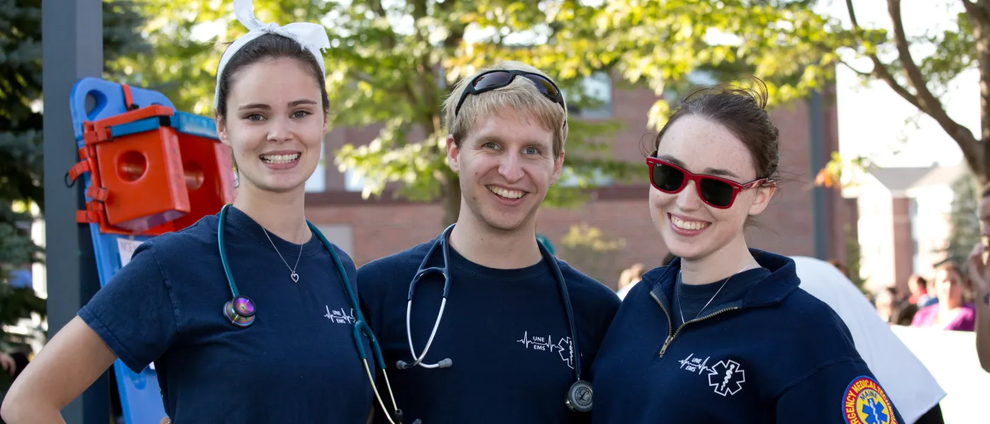 Three members of the U N E E M S Club pose at the annual Involvement Fair