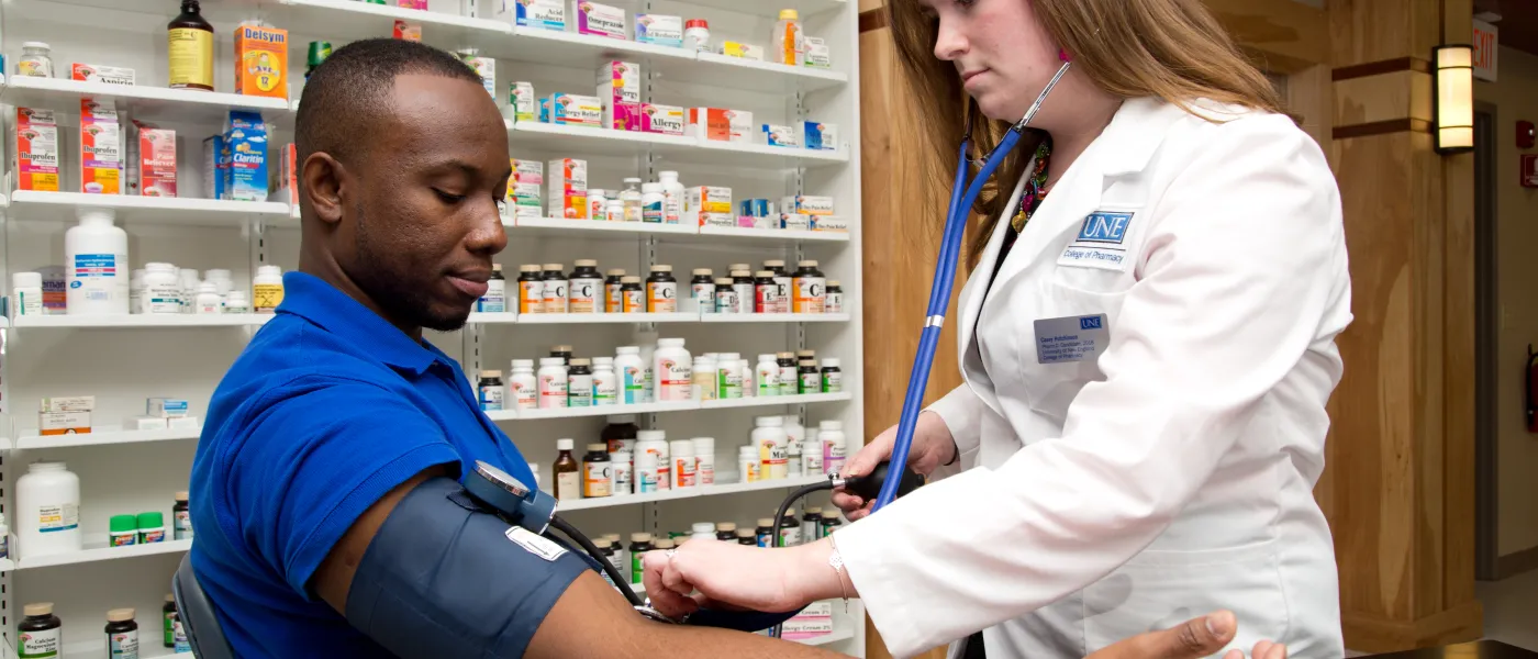 U N E College of Pharmacy student takes a patient's blood pressure