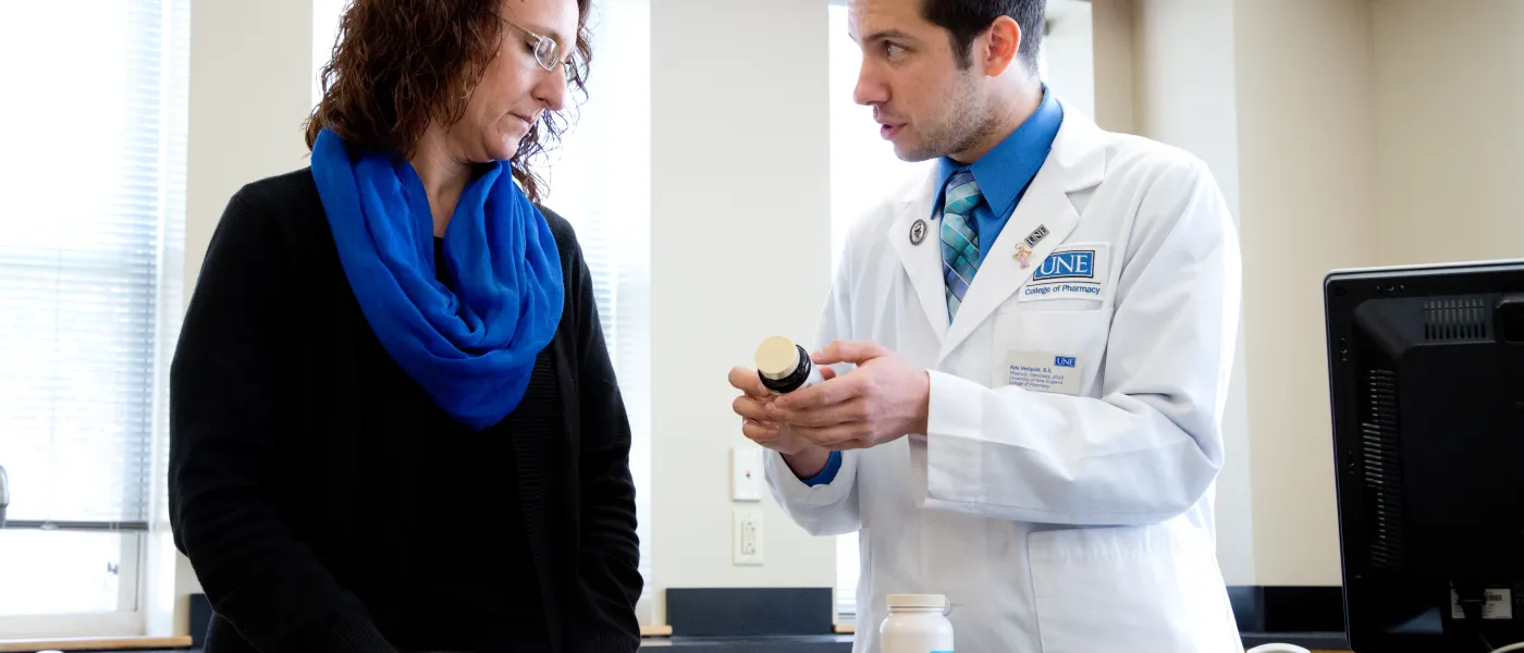 U N E pharmacy student shows a patient a prescription