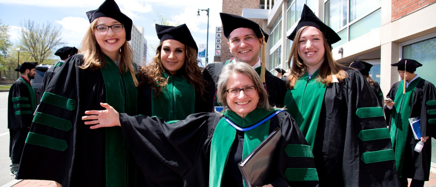A group of faculty pose outside of commencement