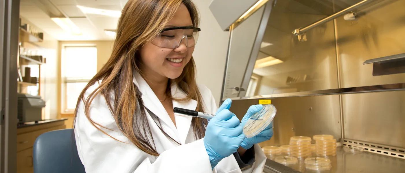 A female science student holds a petri dish