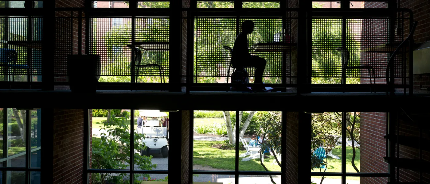 Student sits at a desk by a window in Blewitt Hall