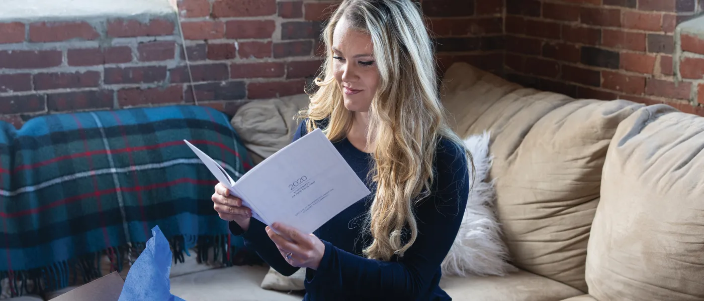 Lauren Ferguson reads through the 2020 U N E COM Commencement program.