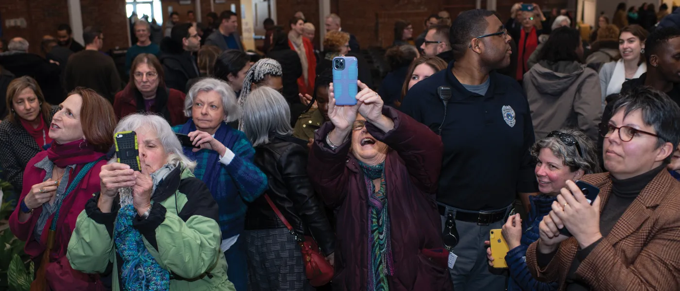 Many in the crowd raise their phones as Abrams makes her exit from Innovation Hall.