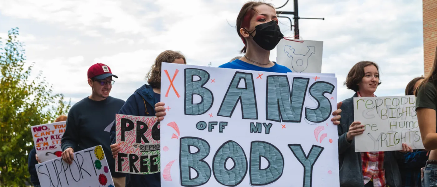 U N E students holding posters and walking during the Women's March