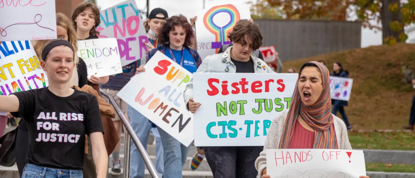 U N E students holding posters and walking during the Women's March