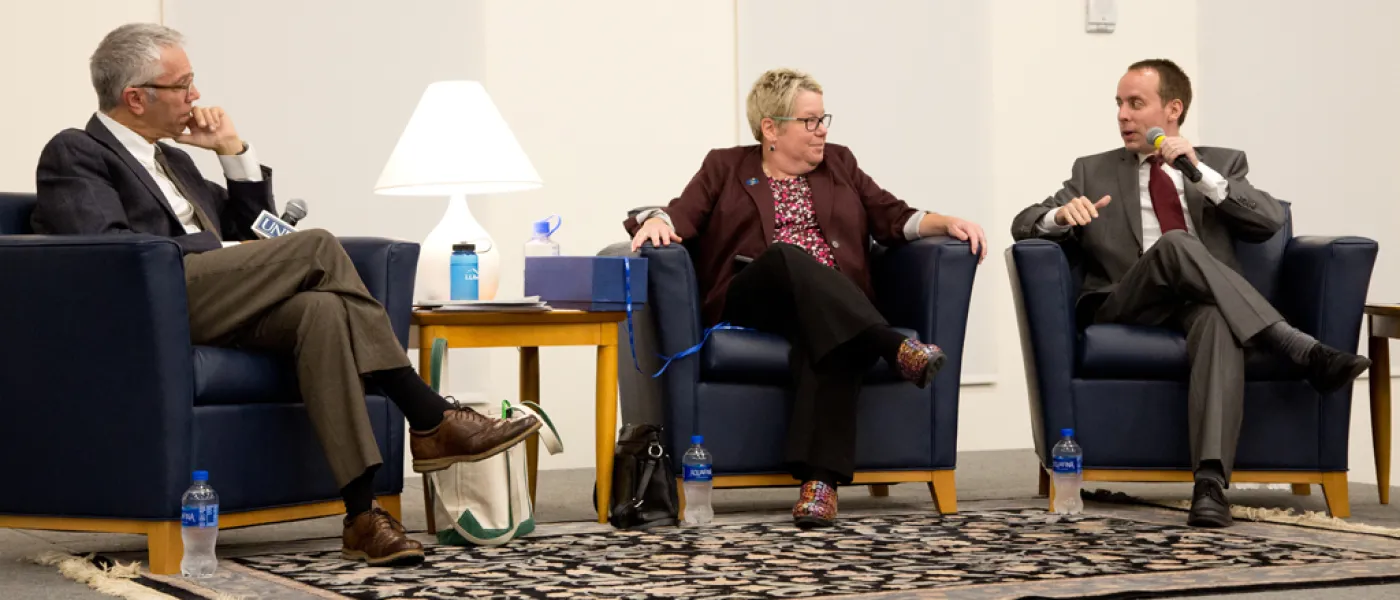 Three speakers on stage at the President's Forum