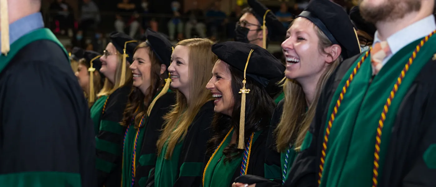 Graduates smile as they watch the ceremony