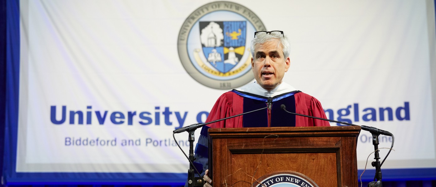 U N E Commecement speaker Jonathan Haidt, Ph.D. stands behind a podium