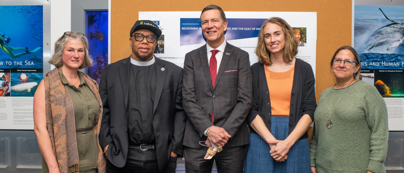 Reverend Lennox Yearwood and President Herbert stand with three others and smile at the camera
