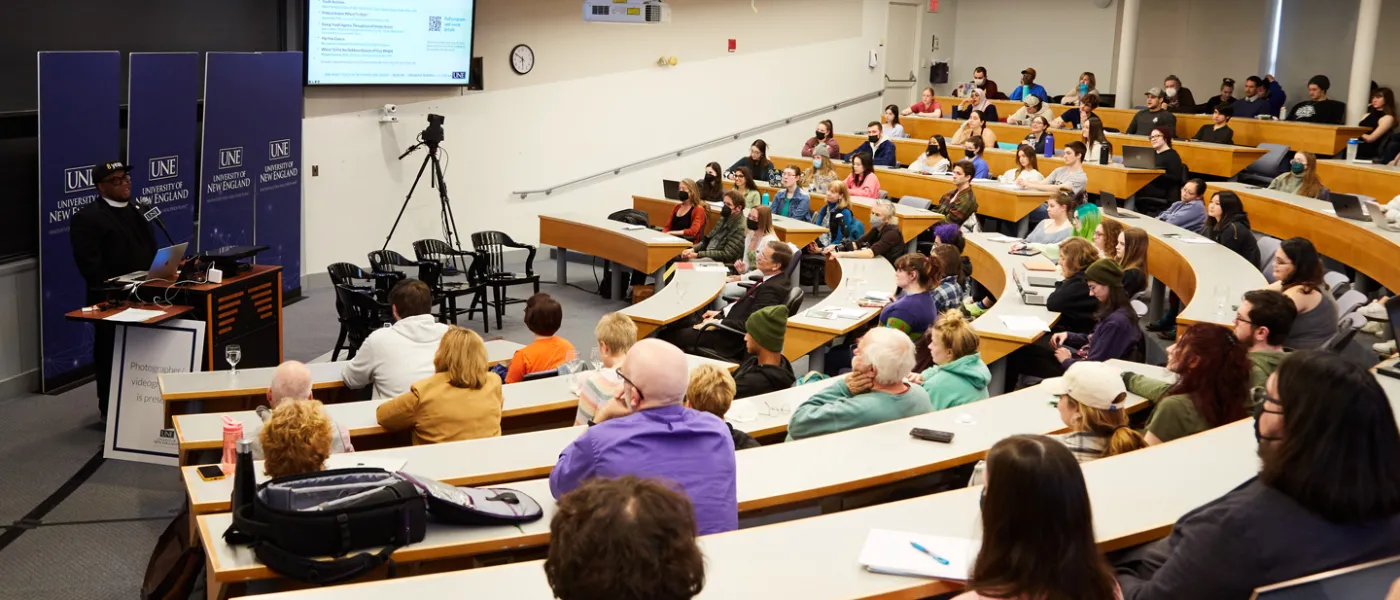 Classroom filled with students and faculty listening to Reverend Lennox Yearwood discussing Climate and Justice