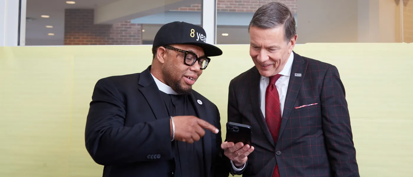 Reverend Lennox Yearwood and President Herbert looking at a cellphone screen