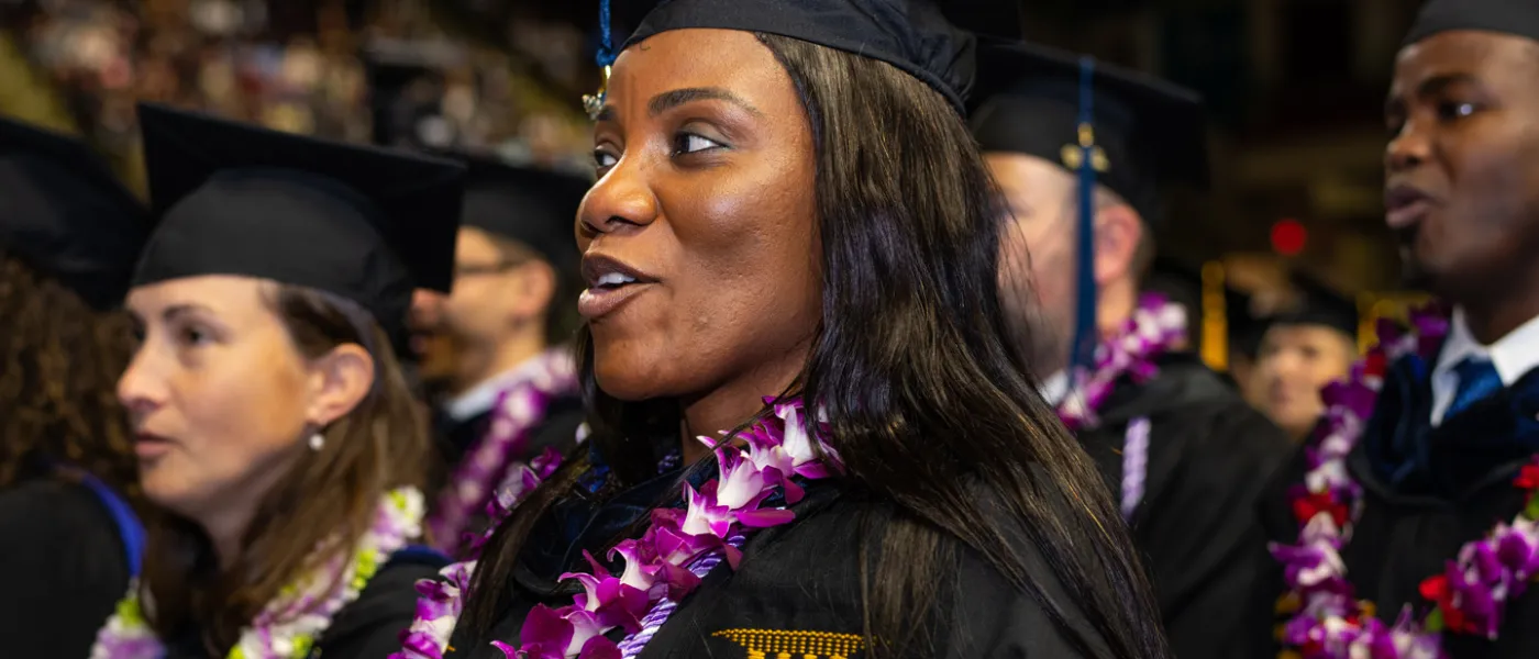 A graduating U N E student smiling at Commencement
