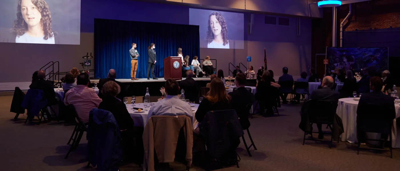 Seated people in Innovation Hall watching a presentation